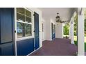 Inviting porch with brick flooring, decorative columns, stylish lighting and shutter accents at 2561 Rogers Rd, Lakeland, FL 33812