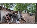 Fenced backyard with overgrown plants and items at 4202 Sunny View Dr, Lakeland, FL 33813