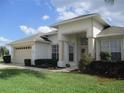 Charming single-story home with a well-manicured lawn, mature landscaping, and an attached two-car garage at 7157 Hazeltine Cir, Lakeland, FL 33810