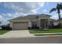 Well-maintained single story home with a two-car garage, neatly trimmed landscaping, and lush green lawn at 7157 Hazeltine Cir, Lakeland, FL 33810