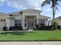 Inviting front entrance featuring glass double doors, decorative shrubbery, and a meticulously maintained lawn at 7157 Hazeltine Cir, Lakeland, FL 33810