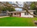 Charming single-story home features a bright red front door, brick column accents and a lush green lawn at 727 Se 12Th St, Ocala, FL 34471