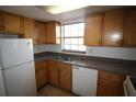 Classic kitchen with wooden cabinets, stainless steel sink, and white appliances at 1000 S Semoran Blvd # 306, Winter Park, FL 32792
