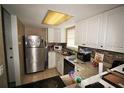 Efficient kitchen featuring white cabinets, granite countertops and stainless steel appliances at 1000 S Semoran Blvd # 404, Winter Park, FL 32792