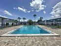 Community pool surrounded by lounge chairs and palm trees, perfect for relaxing at 1000 S Semoran Blvd # 404, Winter Park, FL 32792