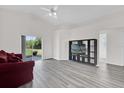 Spacious living room with gray floors, sliding glass doors, and a ceiling fan at 11172 Pinewood Cove Ln, Orlando, FL 32817