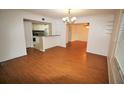 Living area with wood floors, chandelier and sightlines into the kitchen and dining areas at 125 Water Front Way # 200, Altamonte Springs, FL 32701