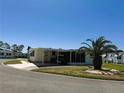 Comfortable home with carport, a tidy yard and a shade-providing palm tree at 129 Dogwood Trl, Leesburg, FL 34748