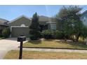 Home's exterior features well-maintained lawn, mature landscaping, and inviting curb appeal at 1810 Centennial Ave, St Cloud, FL 34769