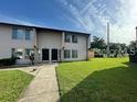 Two story condo building featuring a large grassy area and sidewalk entrance at 2117 Lyme Bay Dr # 604, Orlando, FL 32839