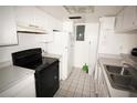 A kitchen featuring tiled floors, white cabinets, and black appliances at 2117 Lyme Bay Dr # 604, Orlando, FL 32839