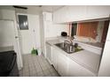 A kitchen featuring white cabinets, tiled floors and stainless steel double sinks at 2117 Lyme Bay Dr # 604, Orlando, FL 32839