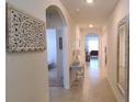Inviting hallway with neutral walls, tile flooring, and an decorative mirror and artwork at 2688 Magnolia Ave, Davenport, FL 33837