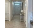 Bright hallway featuring tile flooring, neutral paint, and a console table at 2688 Magnolia Ave, Davenport, FL 33837