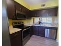This kitchen features wood cabinets, stainless steel appliances, and light countertops at 3475 Flossmoor Ave # 103, Orlando, FL 32822