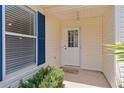 Inviting front entrance with a white door, blue shutters, and a neatly kept entryway at 424 Valverda Dr, The Villages, FL 32162