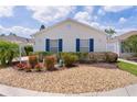 Charming one-story home with blue shutters and a meticulously maintained front yard at 424 Valverda Dr, The Villages, FL 32162