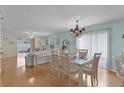 Bright and airy living room with hardwood floors and a chandelier over the dining table at 424 Valverda Dr, The Villages, FL 32162