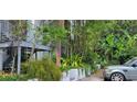 Condo exterior is surrounded by bamboo, banana trees, and other lush greenery with a parked car at 4300 Aqua Vista Dr # A, Orlando, FL 32839