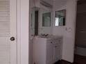 Bathroom features a white vanity with a mirrored medicine cabinet, vanity lighting, and a view of the toilet at 4302 Aqua Vista Dr # G, Orlando, FL 32839