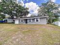 One-story home with a garage, gray facade, and a grassy front lawn at 4680 Sw 142 Place Rd, Ocala, FL 34473