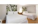 Comfortable bedroom featuring two beds with white linens and bamboo leaf artwork at 5245 W Irlo Bronson Memorial Hwy # 113, Kissimmee, FL 34746