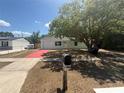 Charming single-story home featuring a well-manicured lawn and a red driveway at 6124 Fox Hunt Trl, Orlando, FL 32808