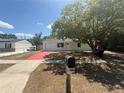 Inviting single-story home with a vibrant red driveway and lush front yard at 6124 Fox Hunt Trl, Orlando, FL 32808
