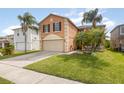 A two-story home featuring an attached garage, lush lawn, and mature palm trees, exuding curb appeal at 709 Crystal Bay Ln, Orlando, FL 32828