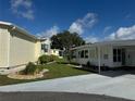 Well-maintained home with a manicured lawn, carport, and landscaping, offering a comfortable living environment at 102 Tangelo Cv, Leesburg, FL 34748