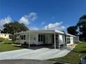 Inviting home with covered parking, lush landscaping, and a welcoming facade at 102 Tangelo Cv, Leesburg, FL 34748