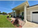 Inviting covered front porch featuring brick flooring and stylish landscaping at 10640 Vista Del Sol Cir, Clermont, FL 34711