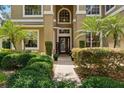 Inviting front entrance with manicured shrubs and lovely walkway leading to a welcoming front door at 1085 Harmony Ln, Clermont, FL 34711