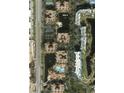 Aerial view of a condo complex featuring a pool, lake, and lush landscaping at 12527 Floridays Resort Dr # 406-E, Orlando, FL 32821