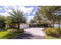 Spacious driveway leading to a well-maintained home with a three-car garage and mature landscaping at 12765 Se 143Rd Ave, Ocklawaha, FL 32179