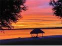 A cozy tiki hut sits on the beach, offering shade and a place to unwind with breathtaking sunset views at 12765 Se 143Rd Ave, Ocklawaha, FL 32179
