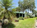 Beautiful home exterior with lush landscaping and a covered porch at 201 Jacaranda Dr, Leesburg, FL 34748