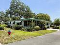 Inviting single-story home with a screened porch, lush landscaping, and a convenient covered carport at 201 Jacaranda Dr, Leesburg, FL 34748