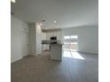 Bright, open kitchen with white cabinets, stainless steel appliances, and an island overlooking the living area at 2117 Emma Ln, Lake Wales, FL 33898