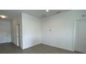 Minimalist living area featuring light grey tiled floors, neutral wall colors and doors leading to other rooms at 2117 Emma Ln, Lake Wales, FL 33898