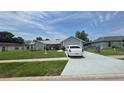 Traditional single-story home featuring a landscaped front yard and a long private driveway at 303 Silk Oak Dr, Kissimmee, FL 34743