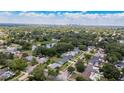 Panoramic aerial view of a residential neighborhood showcasing tree-lined streets, homes, and a distant city skyline at 4514 Crichton Ln, Orlando, FL 32806