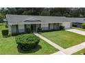 Inviting one-story home boasts a lush front lawn, neat shrubbery, and a concrete walkway to the front door at 4514 Crichton Ln, Orlando, FL 32806