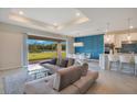Open-concept living room with modern furnishings, patio access, and a view of the lake at 6066 Arbor Watch Loop, Orlando, FL 32829