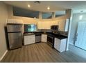 Efficient kitchen design features stainless steel appliances, bright white cabinets and hard surface countertops at 6616 Shepherd Oaks St, Lakeland, FL 33811
