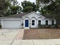 Inviting single-Gathering home featuring a well-maintained lawn and a pop of color at the front door at 901 Cascades Park Trl, Deland, FL 32720