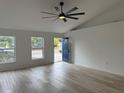 Light-filled living room featuring an oversized ceiling fan and an inviting entry door at 901 Cascades Park Trl, Deland, FL 32720