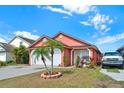 Charming single Gathering home with well maintained landscaping and a two car garage on a beautiful sunny day at 9668 Hollyhill Dr, Orlando, FL 32824