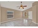 Bright living room featuring tile floors, vaulted ceiling, a ceiling fan and a front door at 9668 Hollyhill Dr, Orlando, FL 32824