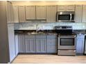 This well-appointed kitchen features stainless steel appliances, ample gray cabinetry, and a stylish marble backsplash at 1010 Dakota Ave, St Cloud, FL 34769